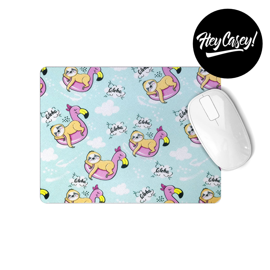 A mousepad with a print of sloths resting on a flamingo pool ring